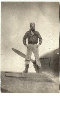 Standing on top of a British fighter found crashed in the desert.